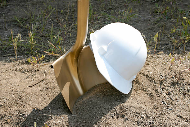 A hard hat and golden shovel await their use in a groundbreaking ceremony.